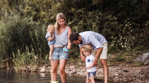 A young family playing by the river representing integral ecology.