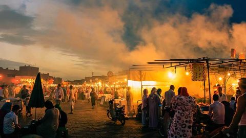 Catholic social teaching being symbolized by people gathering in a marketplace at evening.