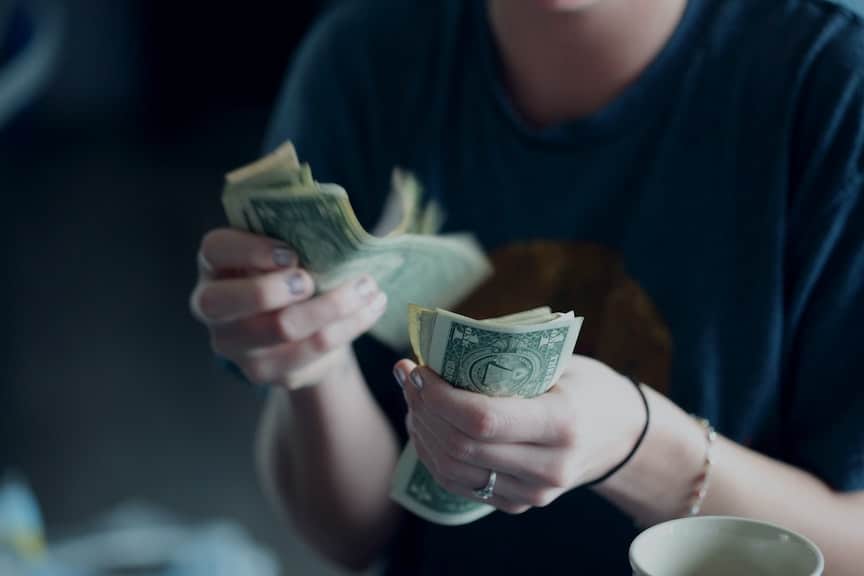 A young woman counts money.